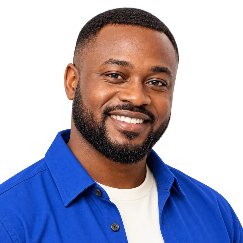 Close-up portrait of a smiling man in a blue shirt looking directly at the camera.